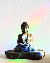 Buddha statue with colorful light effects on a white background