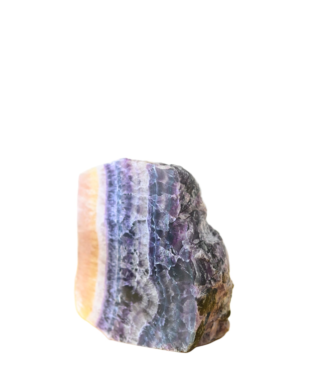 A polished Rainbow Fluorite slab displaying a range of colors including purple, yellow, and blue, placed on a yellow surface.