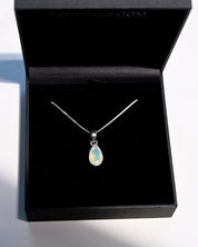 Natural opal pendant close up showing play of color green and gold flash