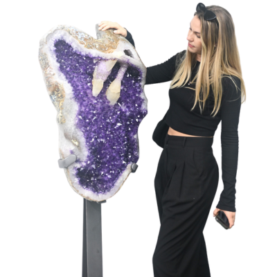 Woman standing next to a decorative purple geode on a white background