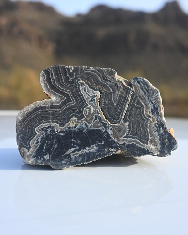Geode with crystal formation on a white surface with blurred natural background