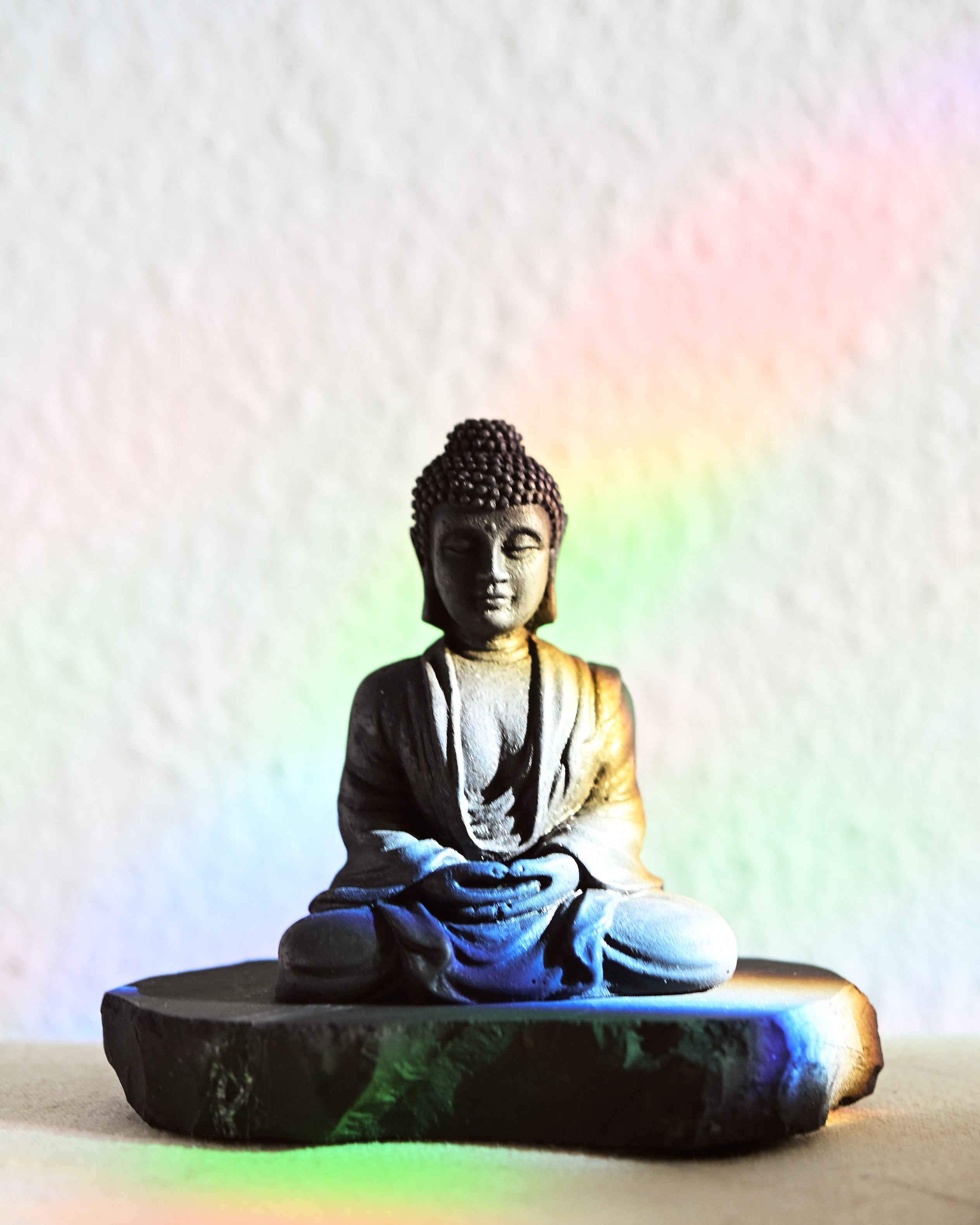Buddha statue with colorful light effects on a white background