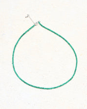Green beaded necklace on a white background