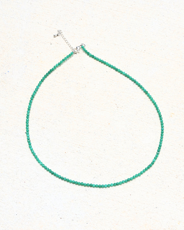 Green beaded necklace on a white background