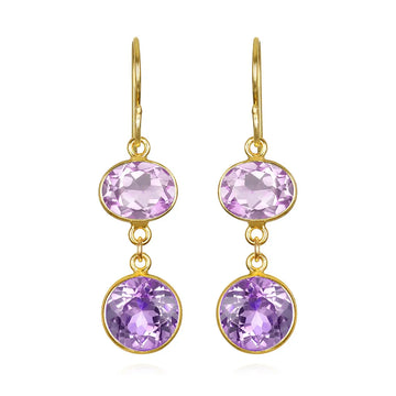 Gold earrings with purple gemstones on a white background