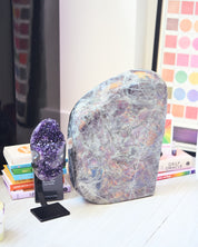 Amethyst geode on stand next to large labradorite freeform - curated bundle