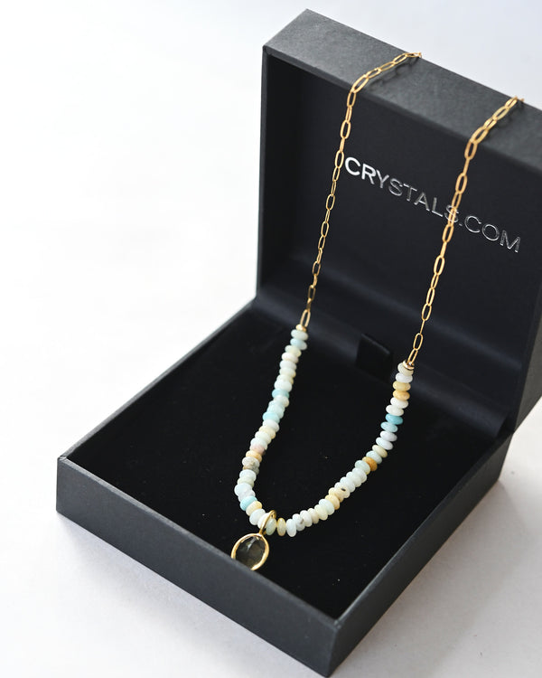 Necklace with beads and a gold chain in a black box with 'CRYSTALS.COM' branding.