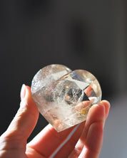 Natural citrine heart with rainbow flashes, held in hand