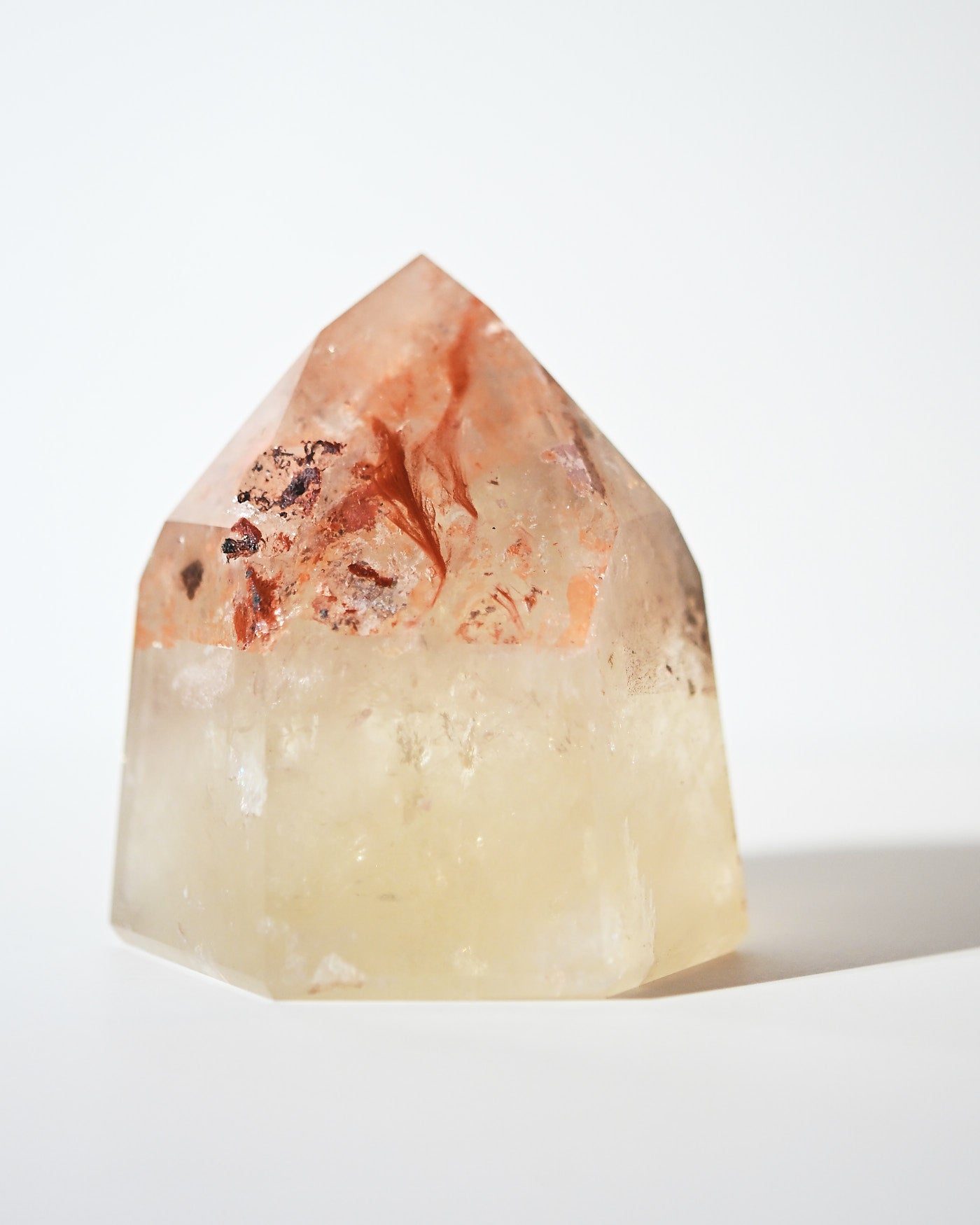 Natural citrine tower with red inclusions near tip, front view