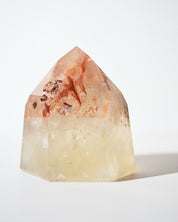 Natural citrine tower with red inclusions near tip, front view