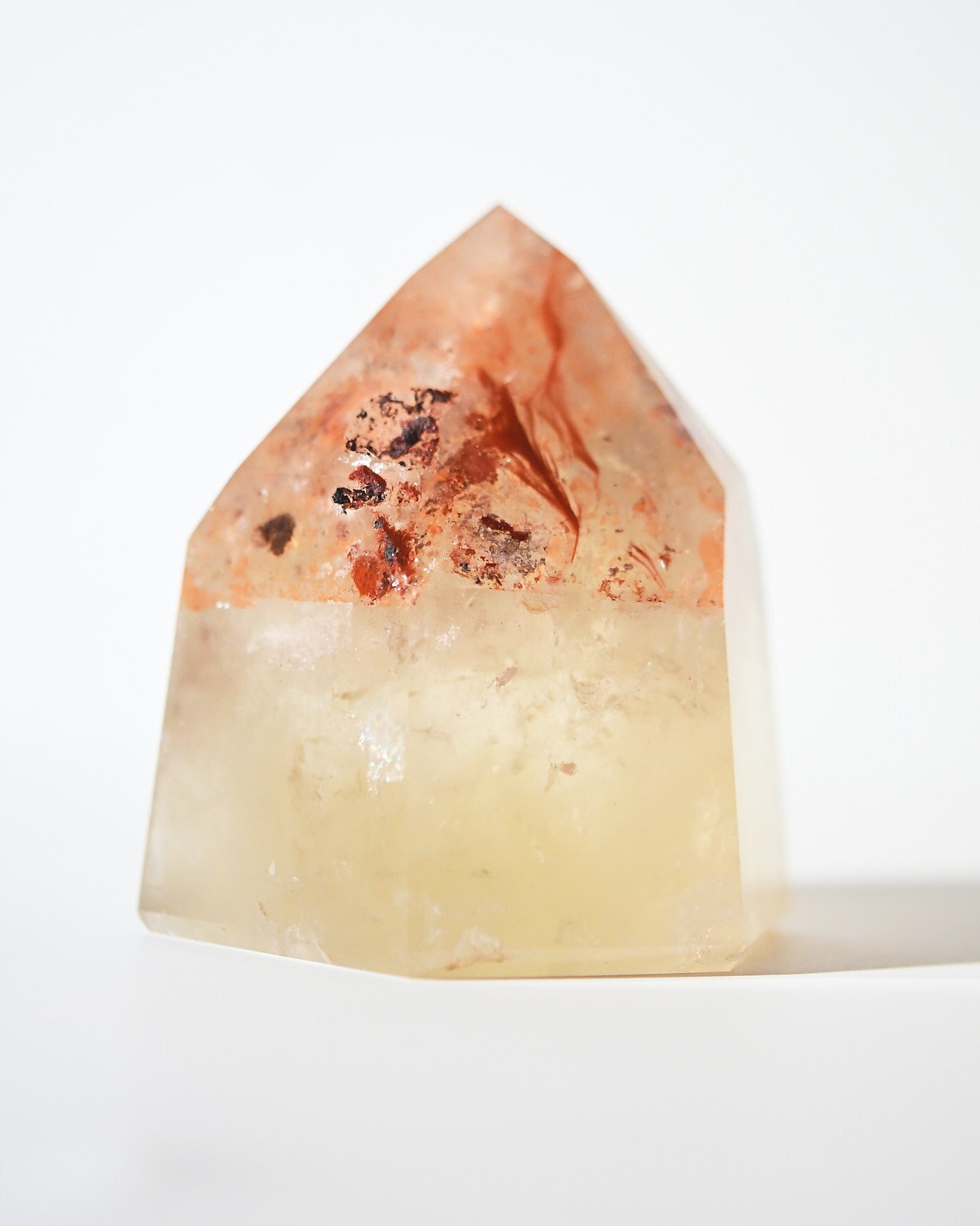 Natural citrine tower with iron oxide inclusions, angled view