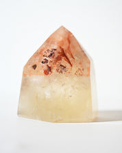 Natural citrine tower with iron oxide inclusions, angled view