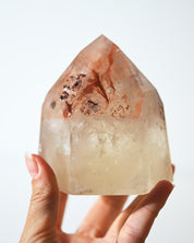 Natural citrine tower with inclusions, held to show scale