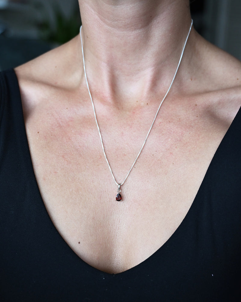 Garnet pendant necklace worn on model, sterling silver box chain