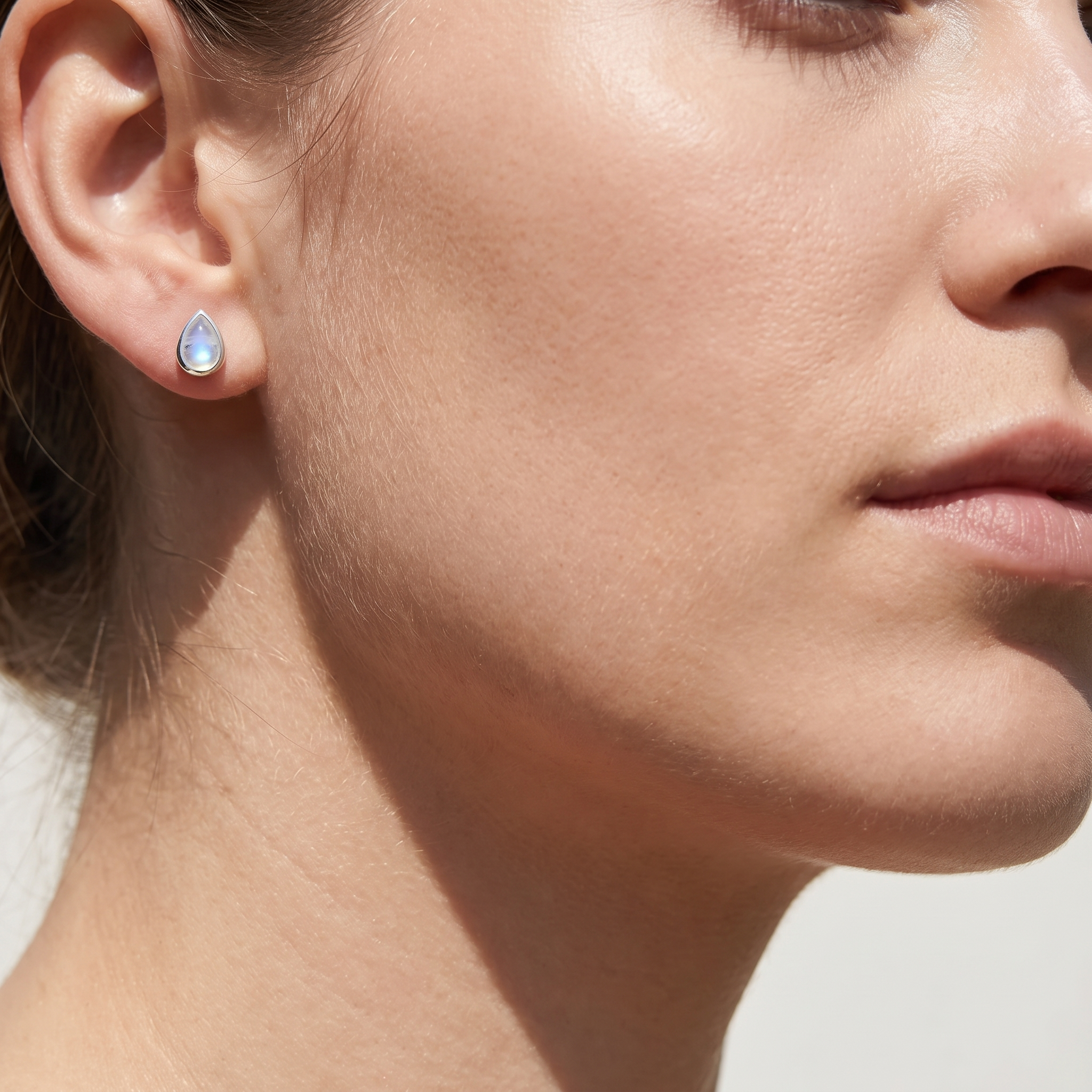 Rainbow Moonstone Teardrop Stud Earring worn on ear - Sterling Silver - Crystals.com