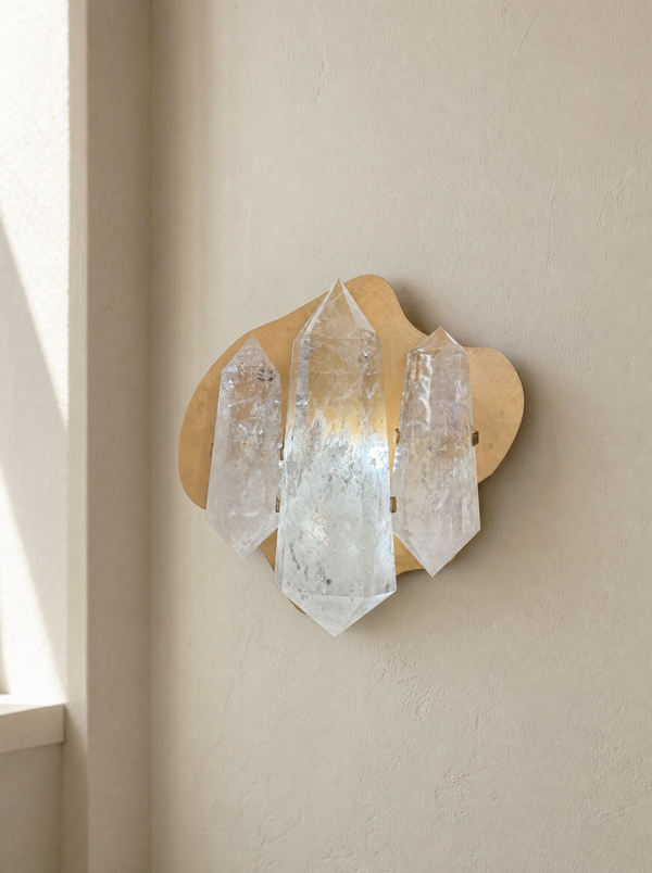 Three double terminated quartz points mounted on a plaster wall in natural light