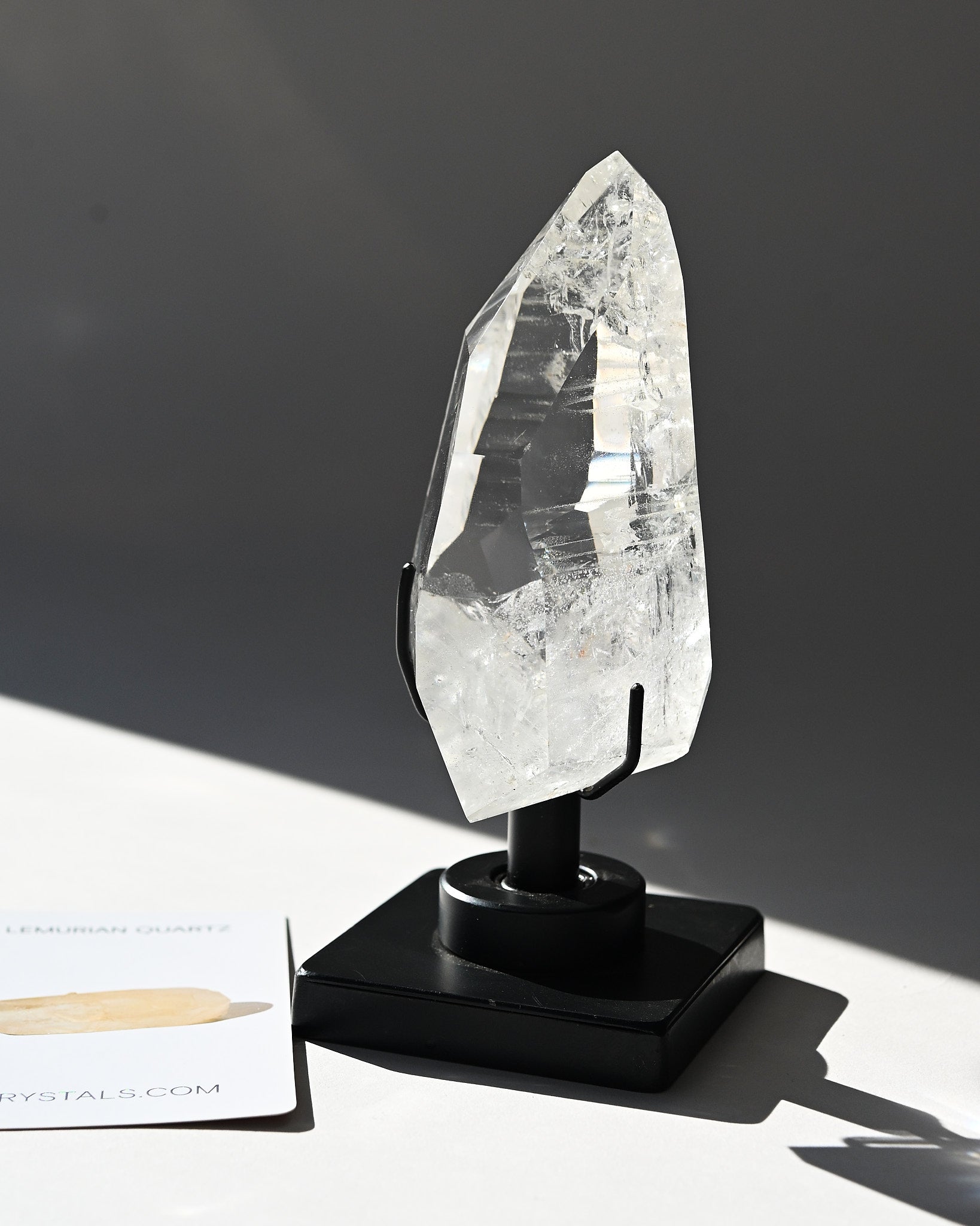 Clear crystal on a black stand against a dark background