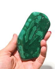 Malachite freeform in hand showing polish and patterns