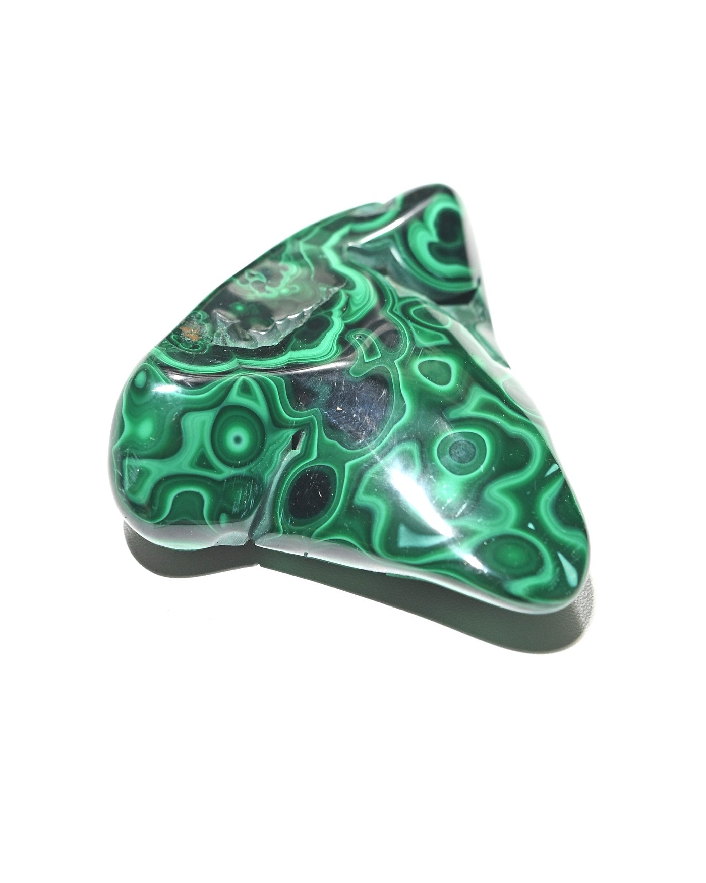 Malachite freeform held in hand for scale