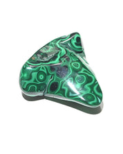 Malachite freeform held in hand for scale
