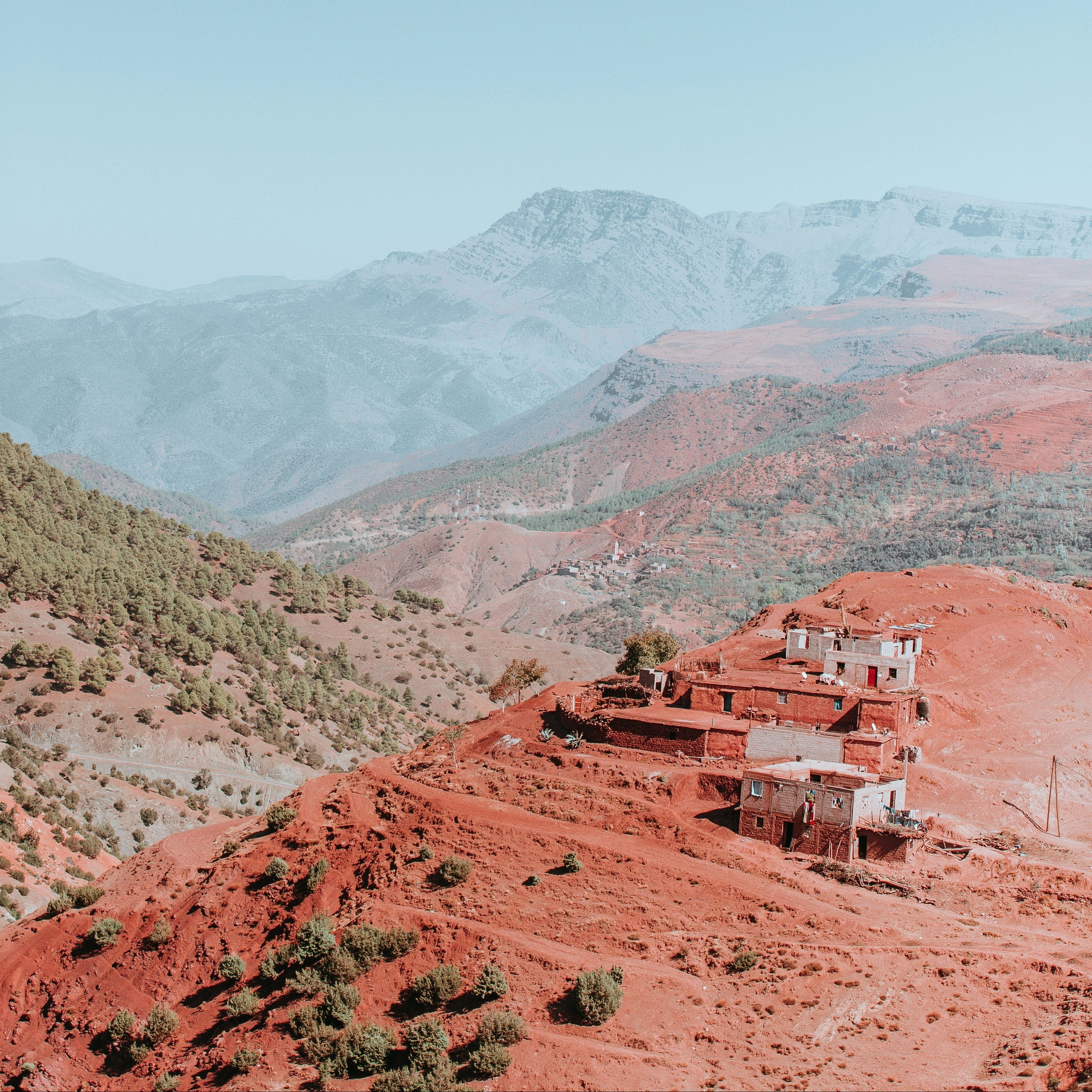 Red mountain landscape with a building and blue sky, morroco crystals 