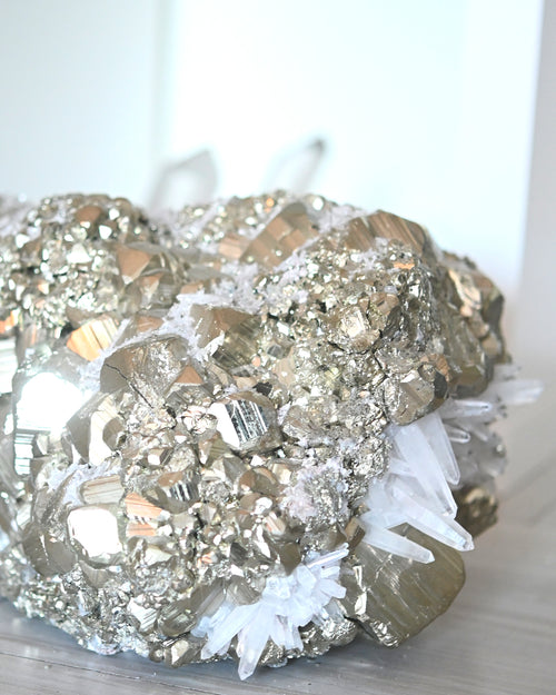 A large, natural cluster of clear quartz with pyrite, displaying shiny metallic looking crystals and sparkling quartz points.