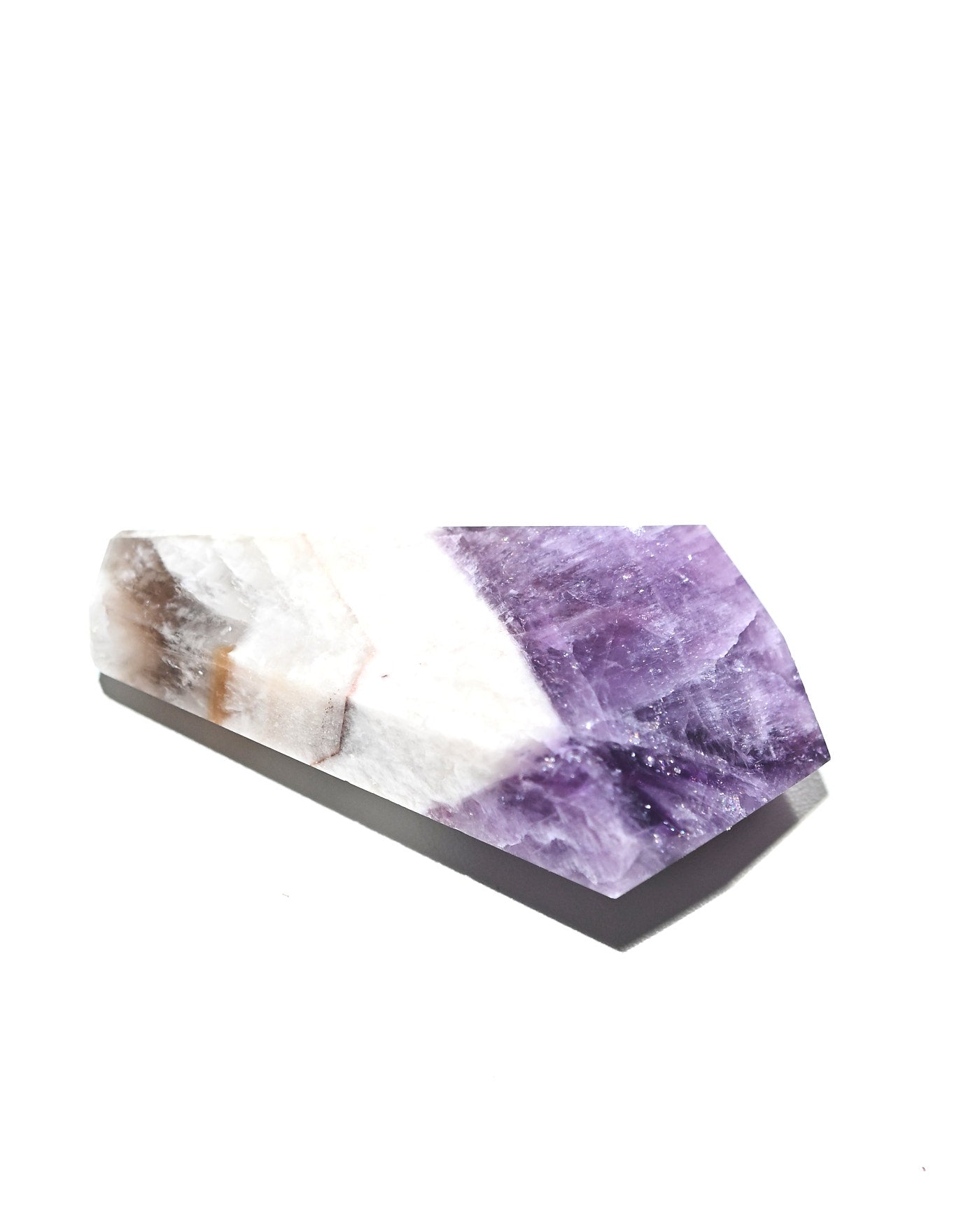 Trapiche amethyst point lying on side showing purple to white color transition