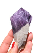 Trapiche amethyst point held in hand showing scale and deep violet color