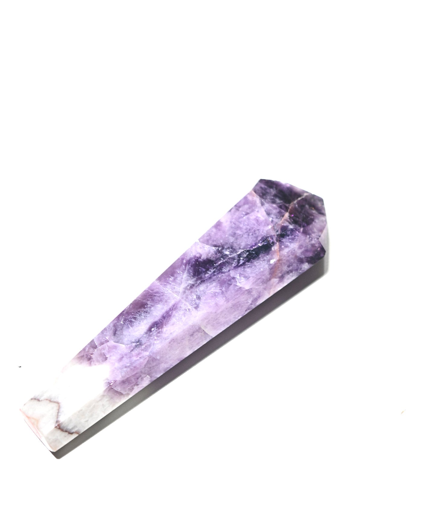 Polished trapiche amethyst tower lying on side showing purple to white transition