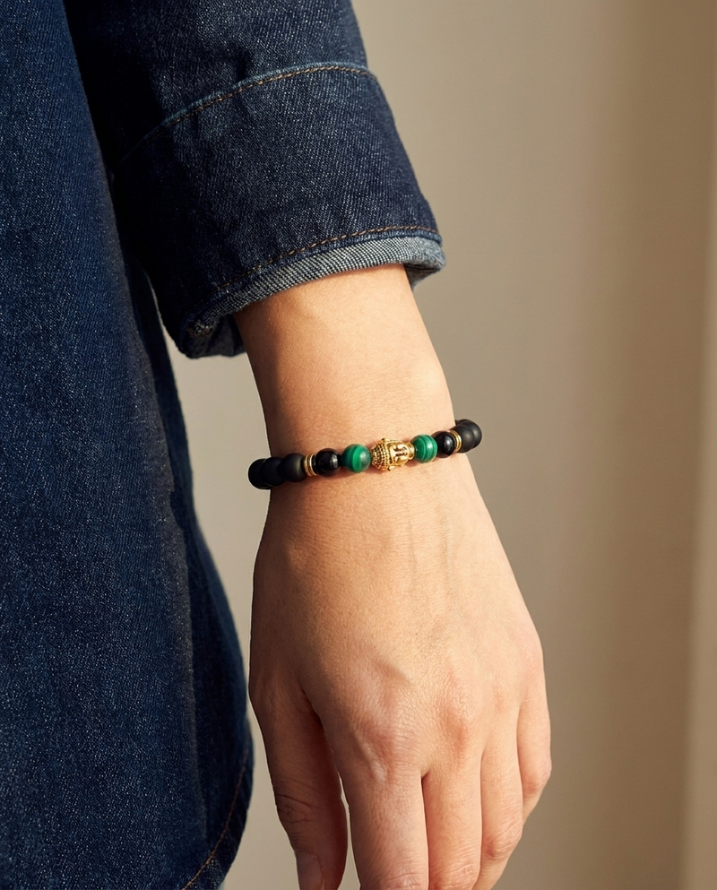 Buddha Stone Malachite Obsidian Bracelet wrist shot - model wearing black obsidian beads with gold Buddha charm