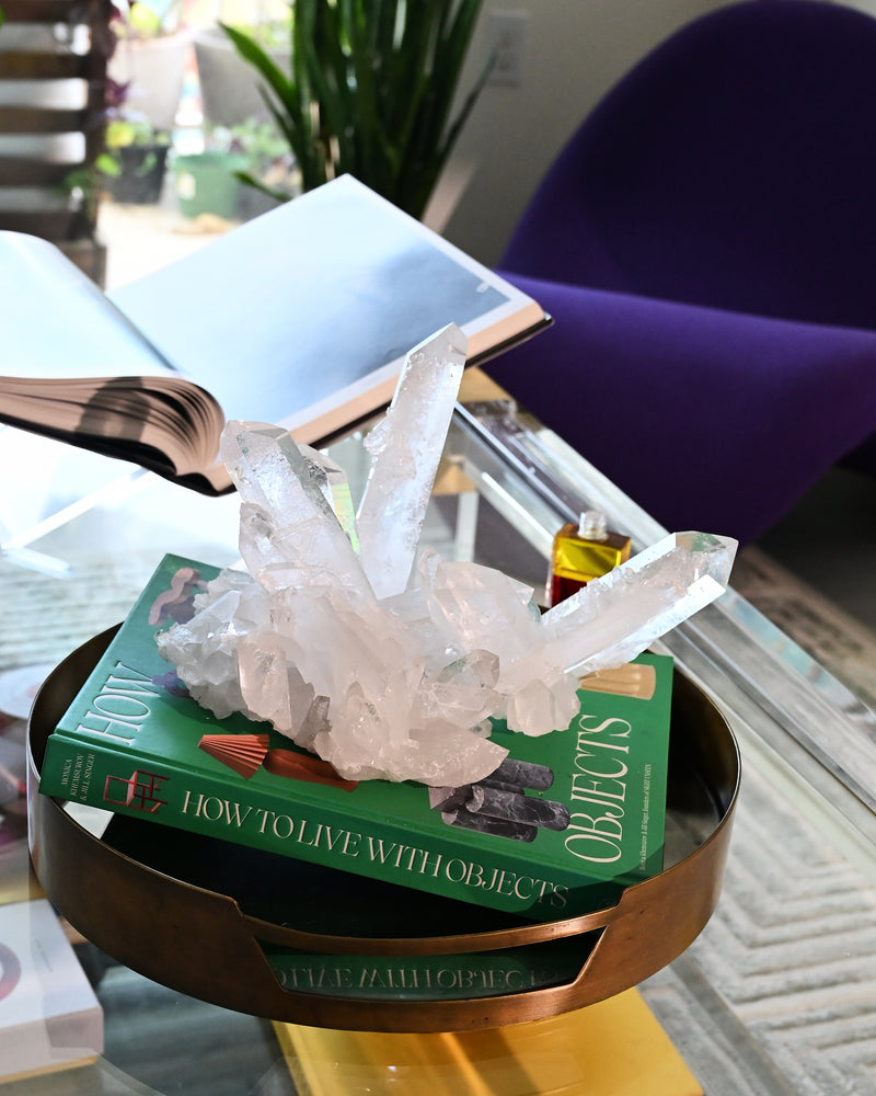 Crystal formation on a book titled 'How to Live with Objects' on a glass table.