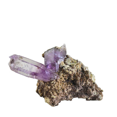 Amethyst crystal on a rock against a white background
